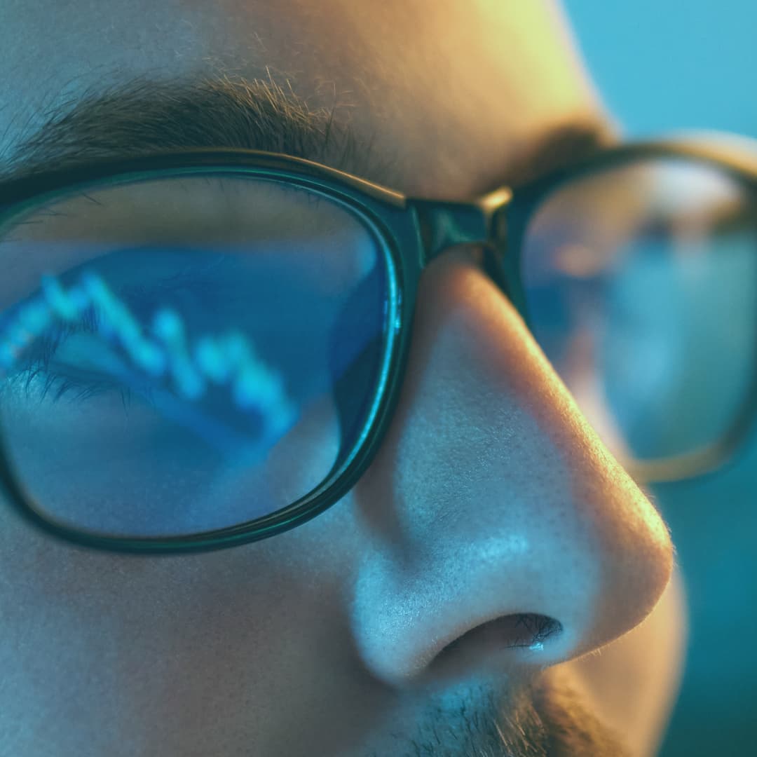 Man wearing glasses reflecting data graph