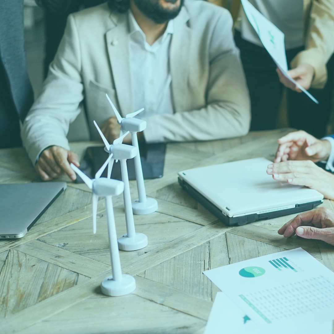Business team around table with model turbines