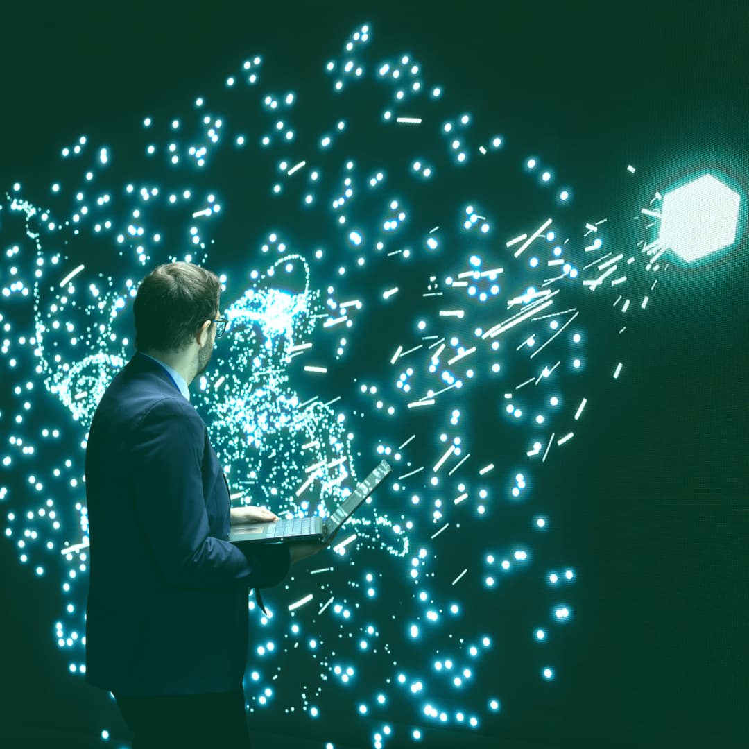 Man on laptop with flashing blue sparks behind
