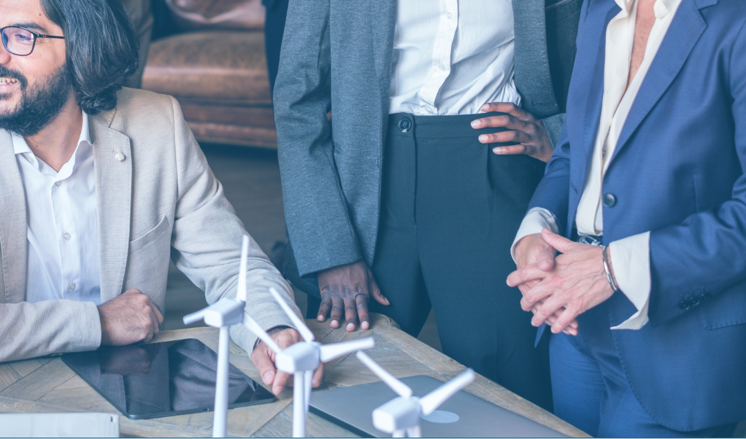 Business team meeting around table with model turbines